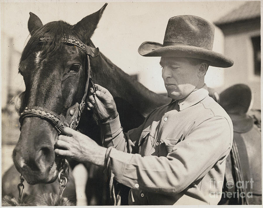 Cliff Smith Adjusting Bridle On Horse Photograph by Bettmann