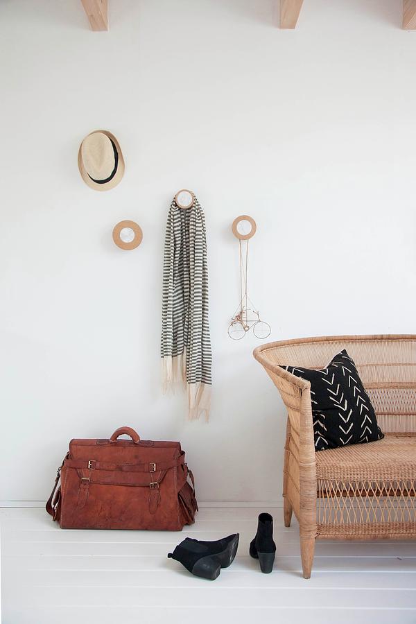 Cloakroom Pegs Made From Round Wooden Discs, Leather Bag And Wicker Sofa Photograph by Holly Marder
