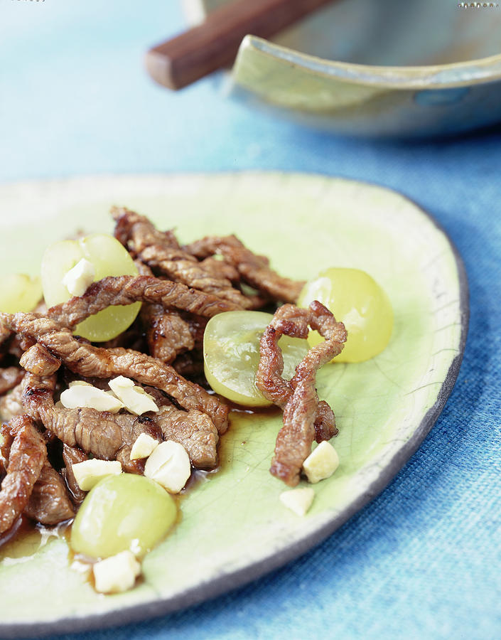 Close-up Of Beef With Grapes And Cashews On Plate Photograph by Jalag ...