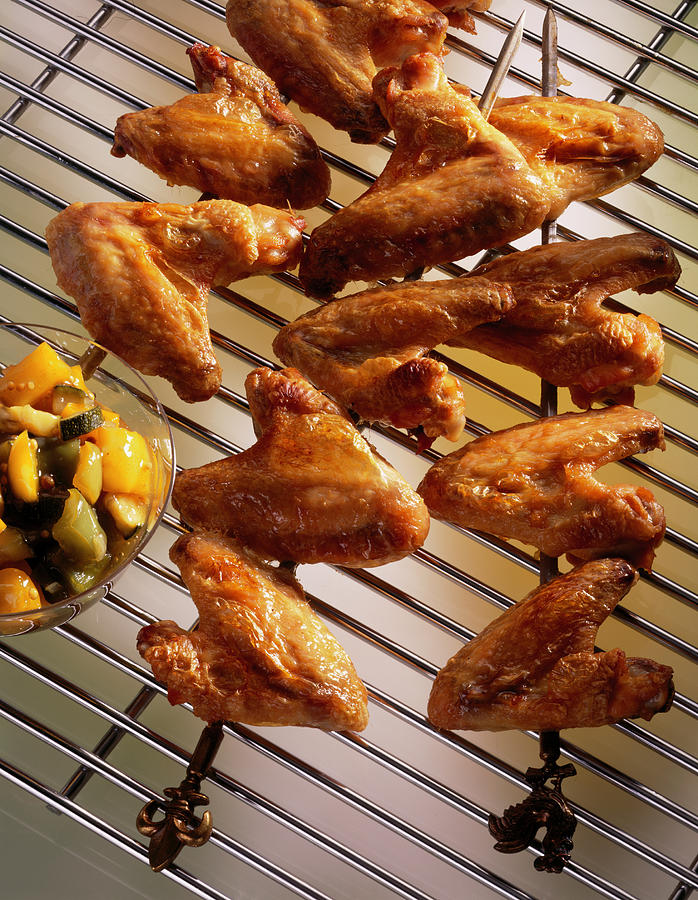 Close-up Of Chicken Wings In Skewers And Zucchini Chutney On Grill Photograph by Jalag / Uwe Bender