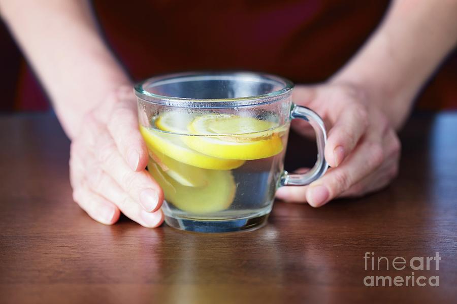 Close-up Of Hands Holding Lemon And Ginger Tea Photograph by Cristina Pedrazzini/science Photo Library