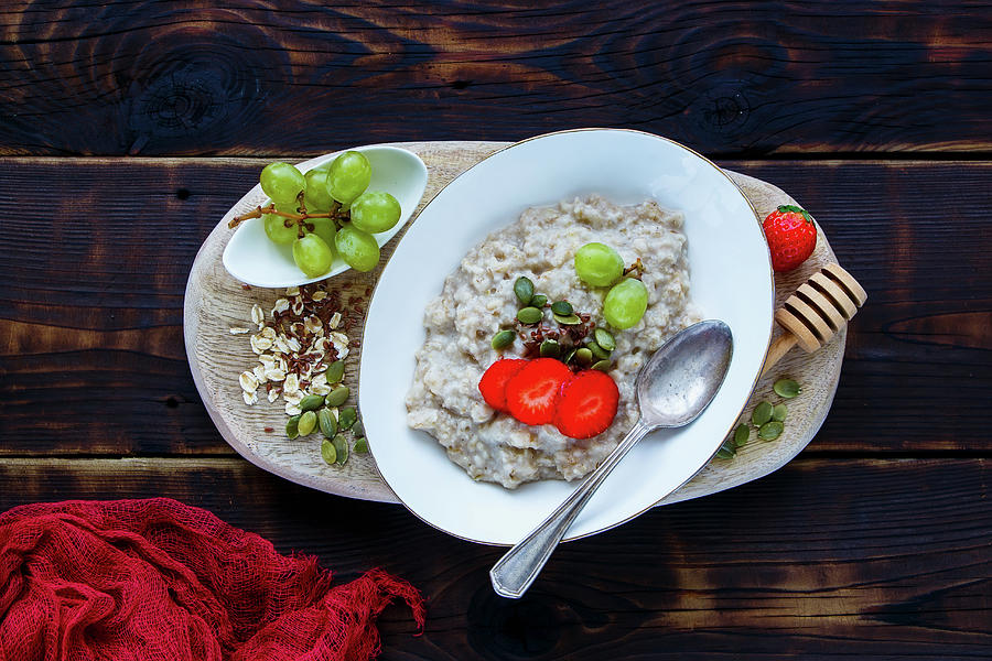Close Up Of Homemade Oatmeal Porridge With Berries And Seeds In Bowl On Dark Rustic Background Photograph by Yuliya Gontar
