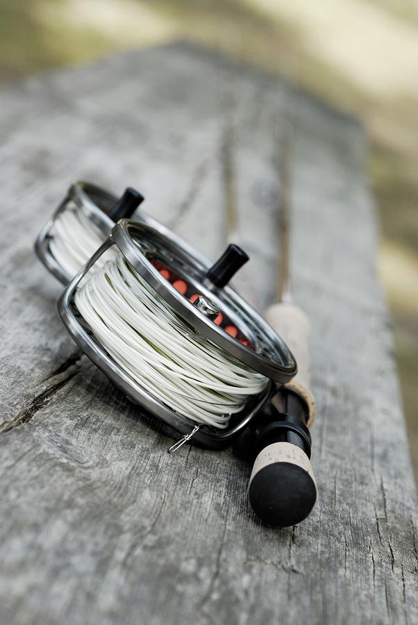 Close-up Of Two Fishing Reels And A Photograph by Glowimages