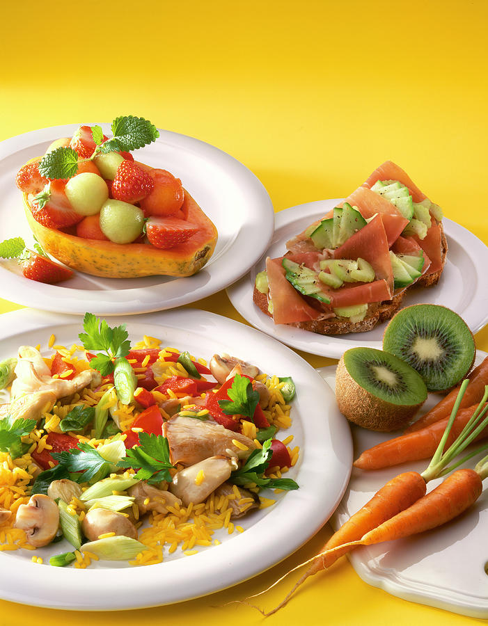 Close-up Of Vegetable Curry Rice, Fruit Salad In Papaya, Ham Sandwich, Kiwi And Carrots Photograph by Jalag / Uwe Bender