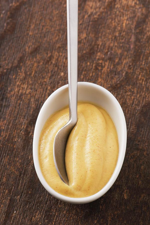 Closeup Of Dijon Mustard In A White Bowl And A Spoon. Photograph by Lars Hallstrm