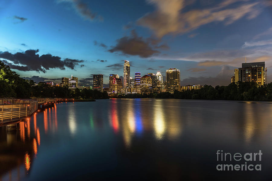 Austin Skyline Photograph - Clouds roll over the Austin Skyline as the neon reflects in the glass-like waters of Lady Bird Lake by Dan Herron