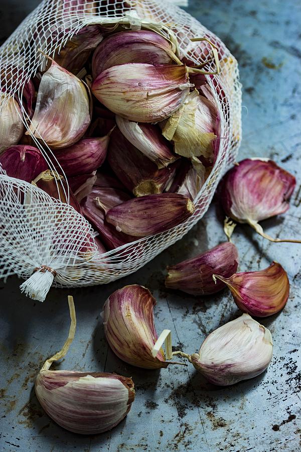 Cloves Of Garlic In A White Net Photograph by Charlotte Von Elm
