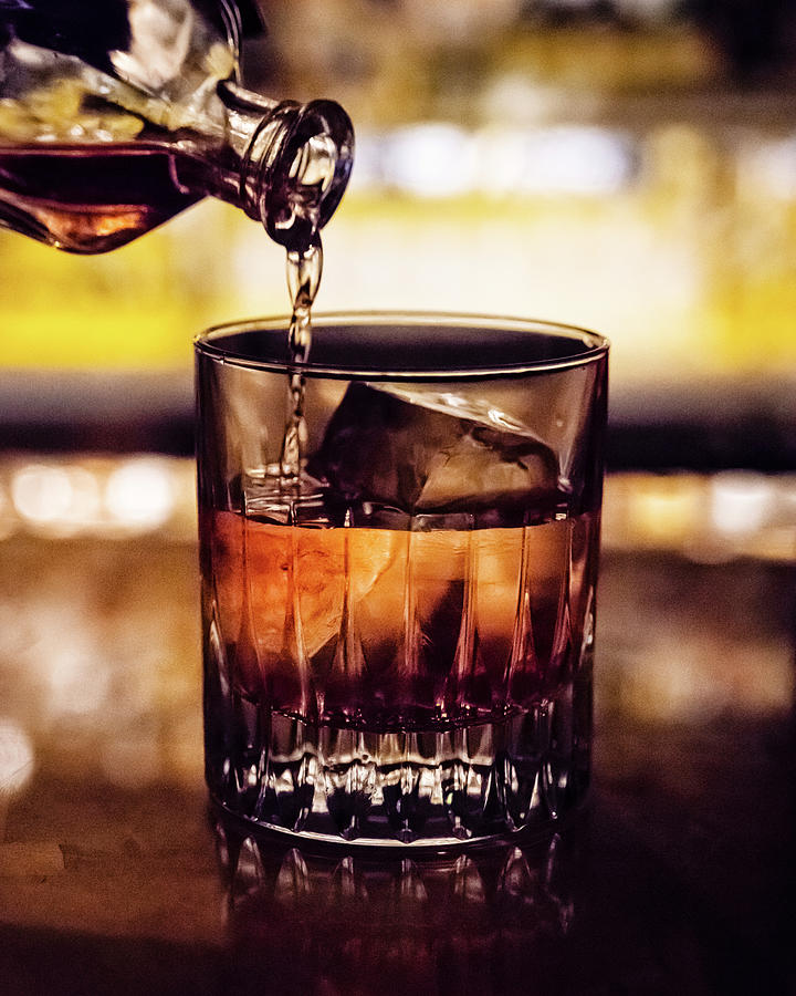 Cocktail Being Poured Into A Rocks Glass Filled With Ice In A Bar ...