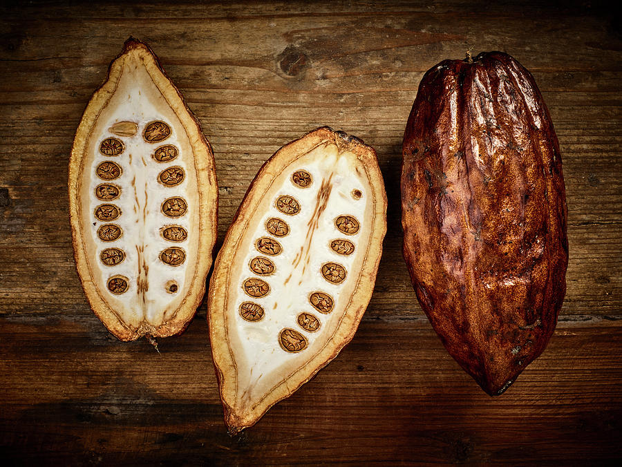 Cocoa Pods, Whole And Halved On A Wooden Background Photograph by Peter Rees