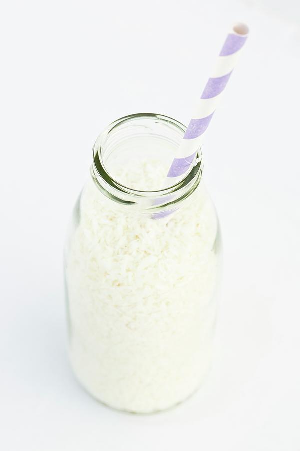 Coconut Flakes In A Milk Bottle With A Straw Photograph by Esther Hildebrandt