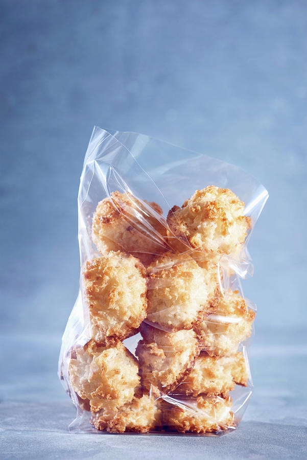 Coconut Macaroons In A Cellophane Bag Against A Blue Background Photograph by Sylvia Meyborg