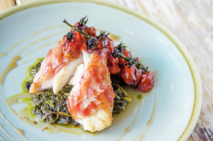 Cod Fillet Wrapped In Bacon On A Bed Of Spinach With Grilled Cherry Tomatoes Photograph by Giulia Verdinelli Photography