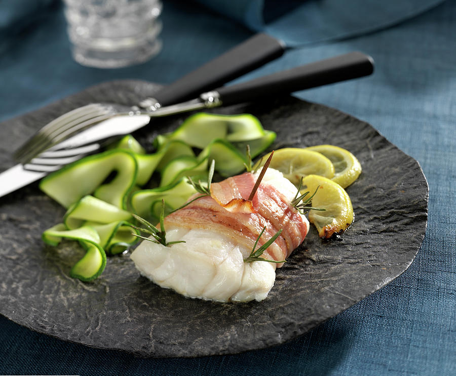 Cod Fillet Wrapped In Smoked Bacon With Rosemary, Thin Strips Of Courgettes And Lemon Photograph by Bertram