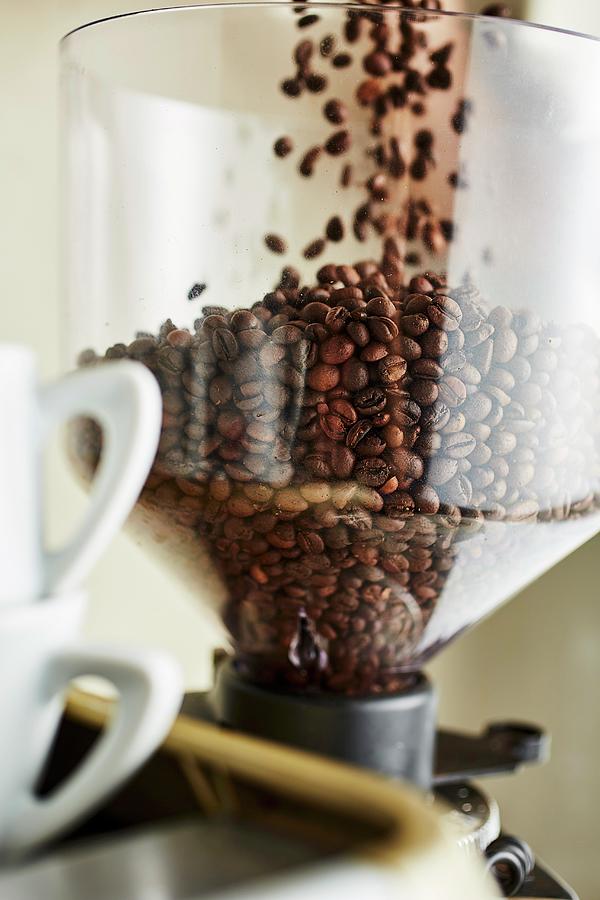 Coffee Beans Falling Into A Coffee Mill Photograph by Herbert Lehmann