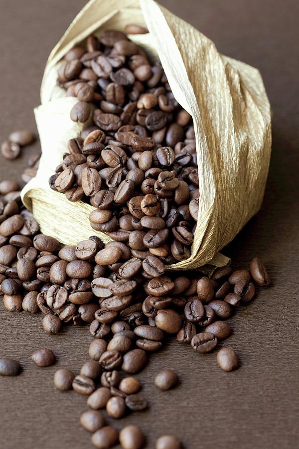 Coffee Beans Falling Out Of A Sack Photograph by Hilde Mche