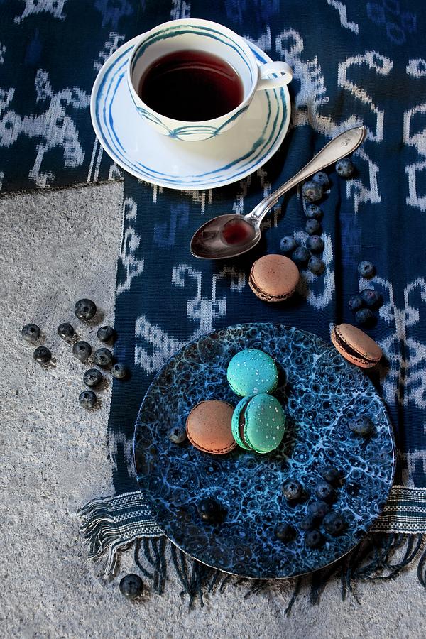 Coffee Cup With Pattern Of Blue Circles And Plate Of Macaroons On Blue And White Cloth Photograph by Annette Nordstrom