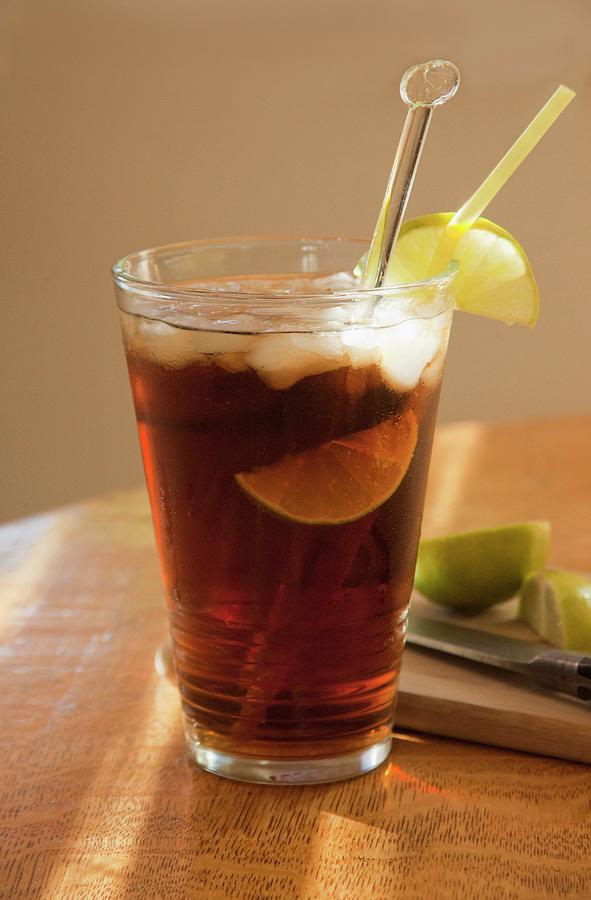 Cola With Rum, Limes And Ice Cubes In A Ray Of Sunshine Photograph by William Boch