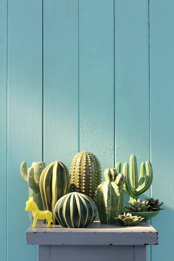 Collection Of Ceramic Cacti In Front Of Blue Board Wall Photograph by Thordis Rggeberg