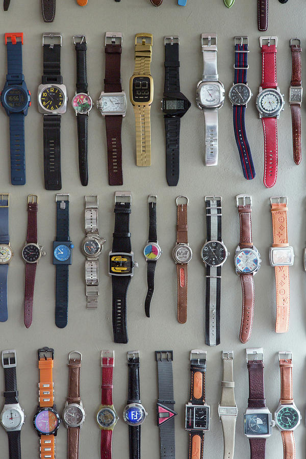Collection Of Watches Hung On Grey Wall In Rows Photograph by Anne-catherine Scoffoni