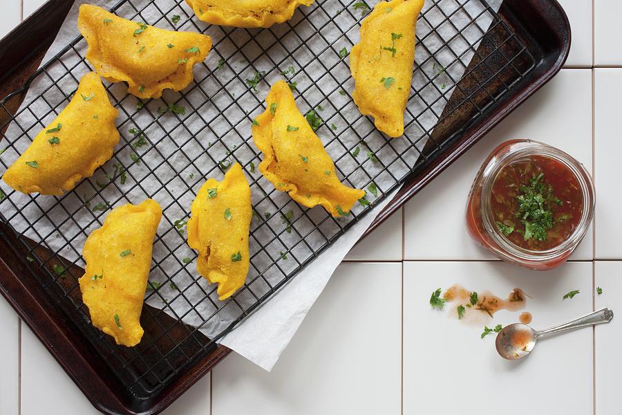 Colombian Empanadas On A Cooling Rack With Salsa seen From Above Photograph by Katharine Pollak