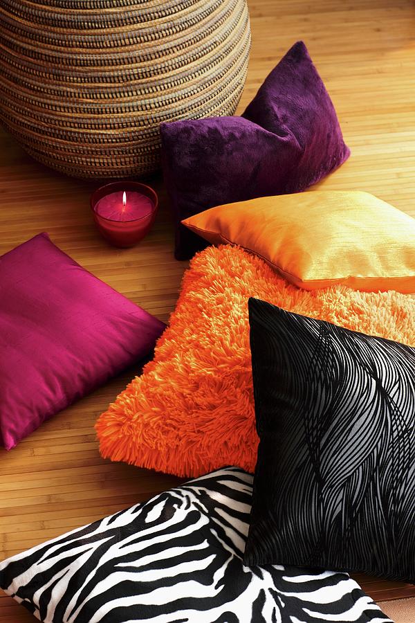 Colorful Decorative Pillows And A Glass Candle Holder On Parquet Floor Photograph by Biglife