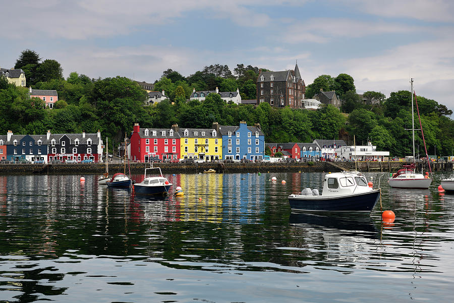 Colorful houses reflected in the water of Tobermory harbour on t Photograph by Reimar Gaertner