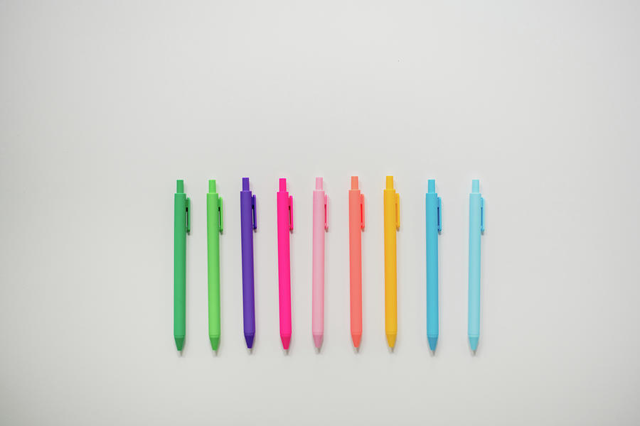 Paintbrush Still Life Photograph - Colorful Pens Lined Up On Plain White Table by Cavan Images