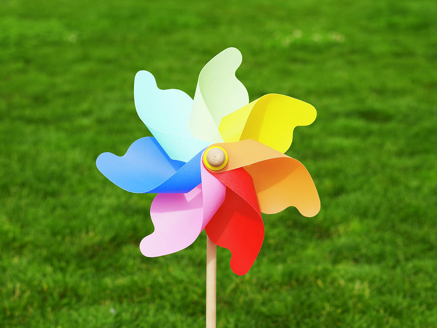 Colorful Pinwheel Against Green Grass Photograph by Ryan Mcvay