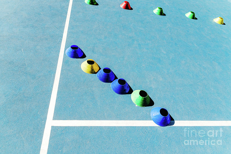 Colorful plastic cones on a blue cement tennis court with white  Photograph by Joaquin Corbalan