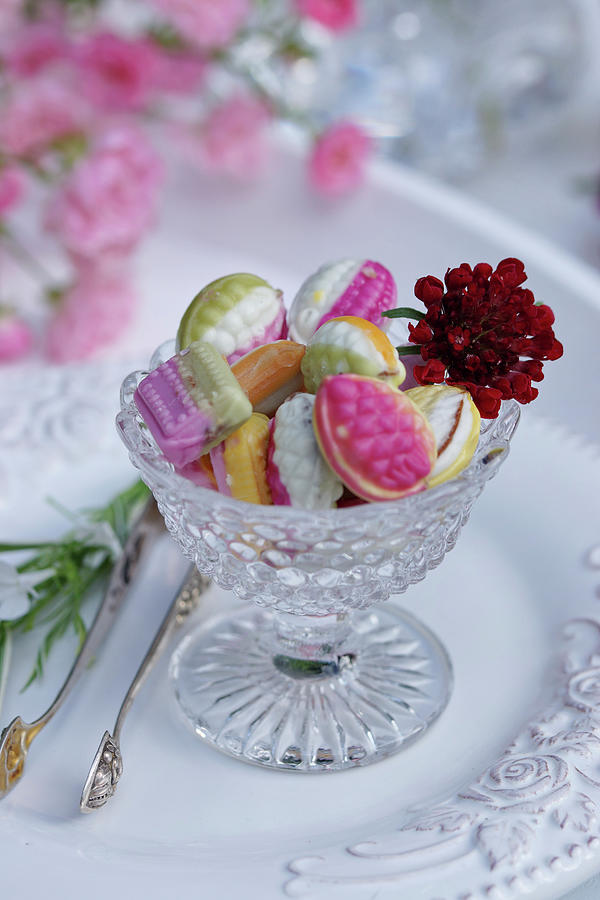 Colourful Bonbons In A Glass Bowl Decorated With A Flower Photograph by Angelica Linnhoff