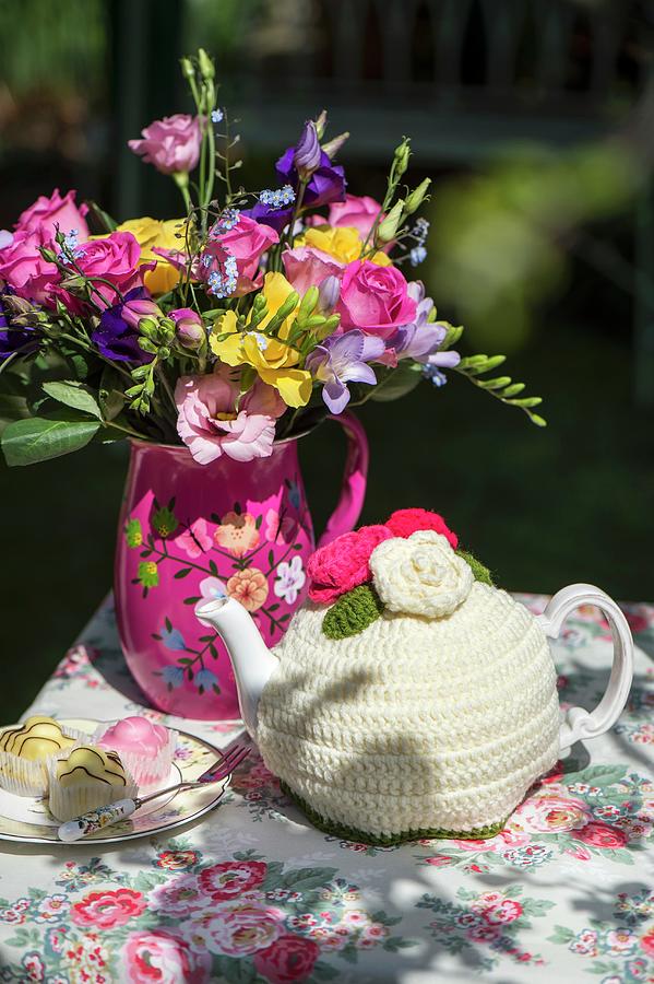Colourful Bouquet, Petit Fours And Teapot In Crocheted Tea Cosy On Floral Tablecloth Photograph by Winfried Heinze