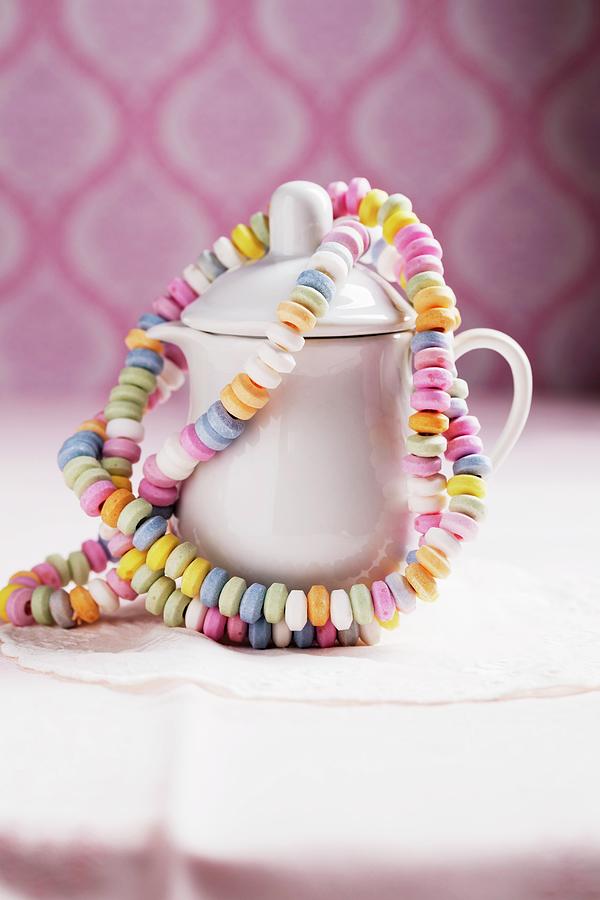 Colourful Candy Bracelets Hanging On A Milk Jug Photograph by Mandy Reschke