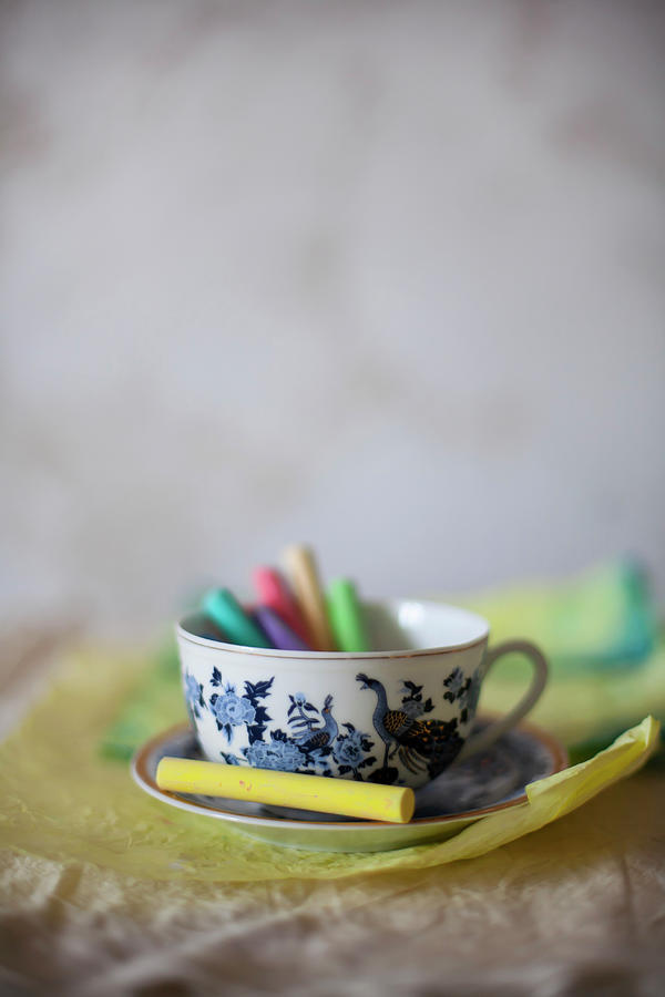 Colourful Chalks In Cup On Crumpled Paper Photograph by Alicja Koll