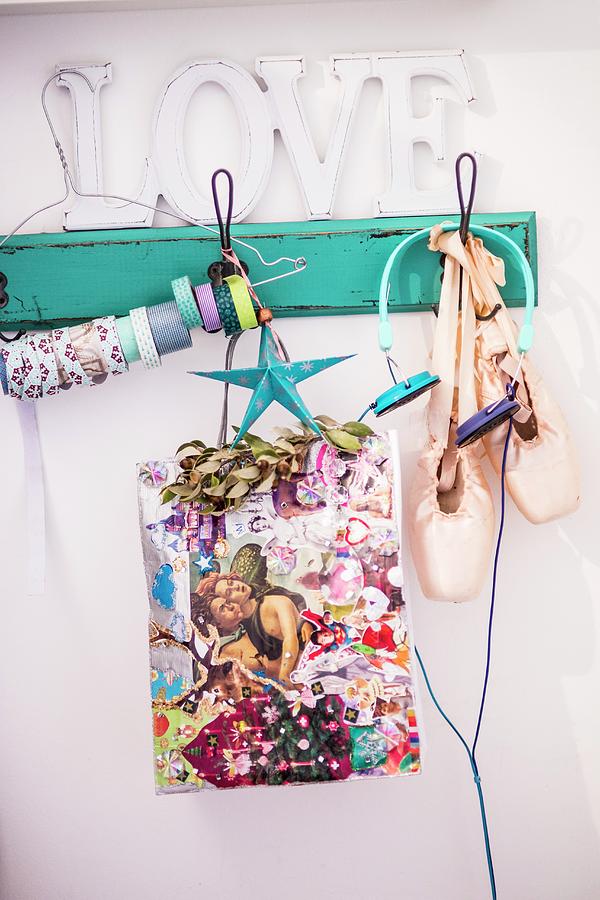 Colourful Christmas Gift Bag, Ballet Shoes And Headphones Hanging From Vintage Coat Rack Painted Turquoise Photograph by Bildhbsch