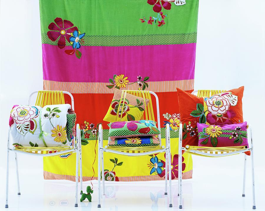 Colourful Cushions On Three Chairs In Front Of Striped Cloth Photograph by Matteo Manduzio