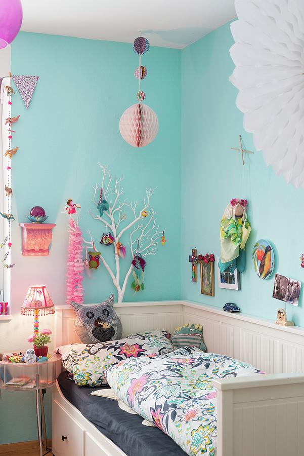 Colourful Decorations On Pale Blue Wall Above Bed In Childs Bedroom Photograph by Ulla@patsy