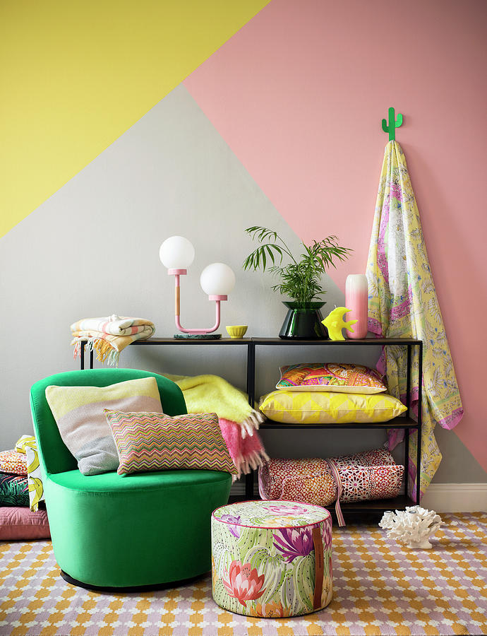 Colourful Design: Striped Cushion On Green Armchair, Floral Pouffe And Home Accessories On Shelves Against Three-tone Wall Photograph by Anderson Karl