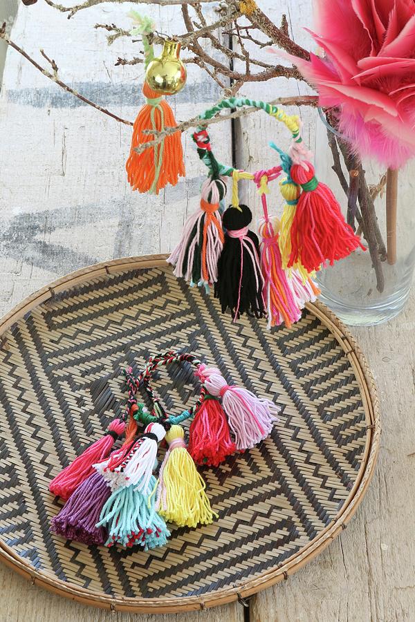Colourful Handmade Woollen Tassels On A Raffia Plate And Hanging On A Twig Photograph by Regina Hippel