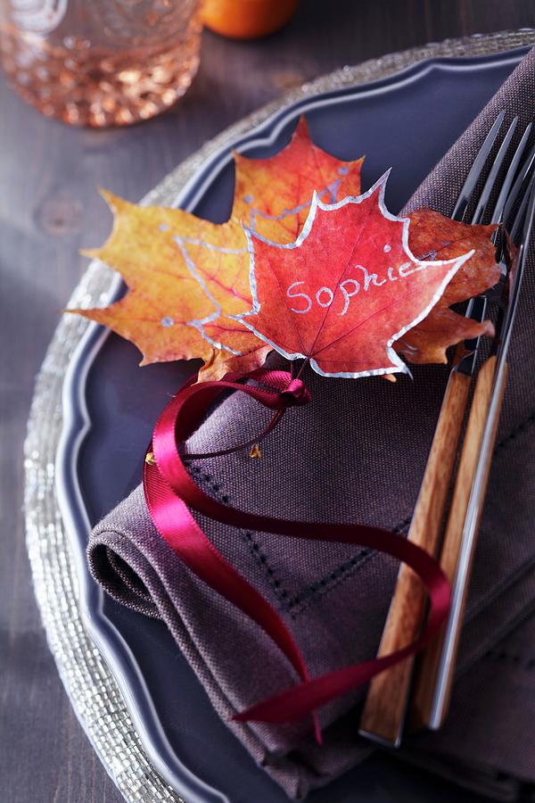 Colourful, Painted Autumn Leaves Used As Name Tag On Plate Photograph by Franziska Taube