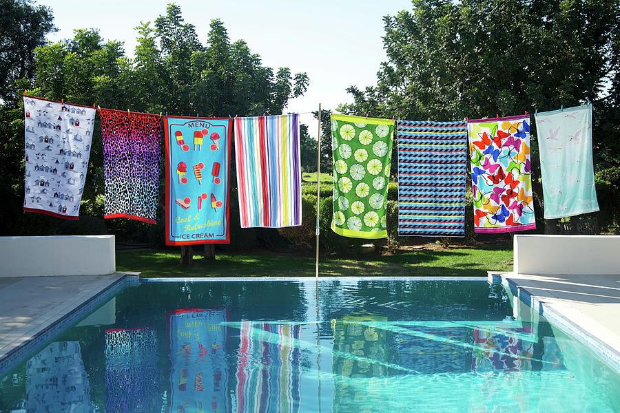 Summer Photograph - Colourful Patterned Towels On Washing Line On Edge Of Pool In Garden by Winfried Heinze