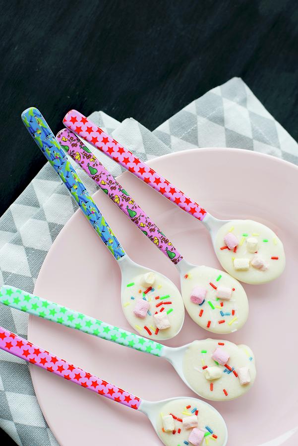 Colourful Spoons Covered With White Chocolate And Bright Hundreds And Thousands Photograph by Ulla@patsy