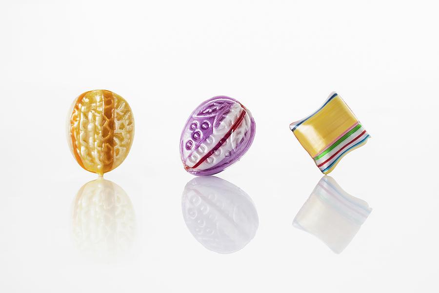 Colourful Sweets On A White Reflective Surface Photograph by Julian Winkhaus