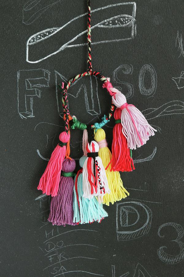Colourful Woollen Tassels For Key Chains Hanging Against Chalkboard Photograph by Regina Hippel