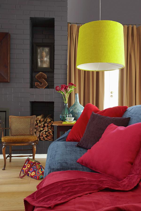 Comfortable Couch With Red Scatter Cushions And Cosy, Red Blanket Below Bright Yellow Pendant Lamp Photograph by Great Stock!