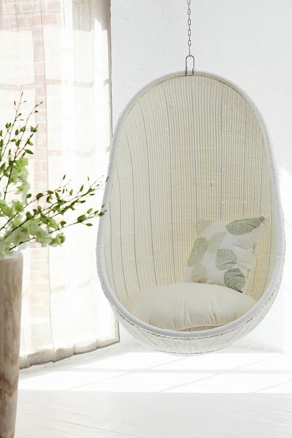 Comfortable, White Wicker Hanging Chair In Corner Of Room Next To Window With Closed, Translucent Curtains And Pattern Of Light And Shadow On Floor Photograph by Great Stock!