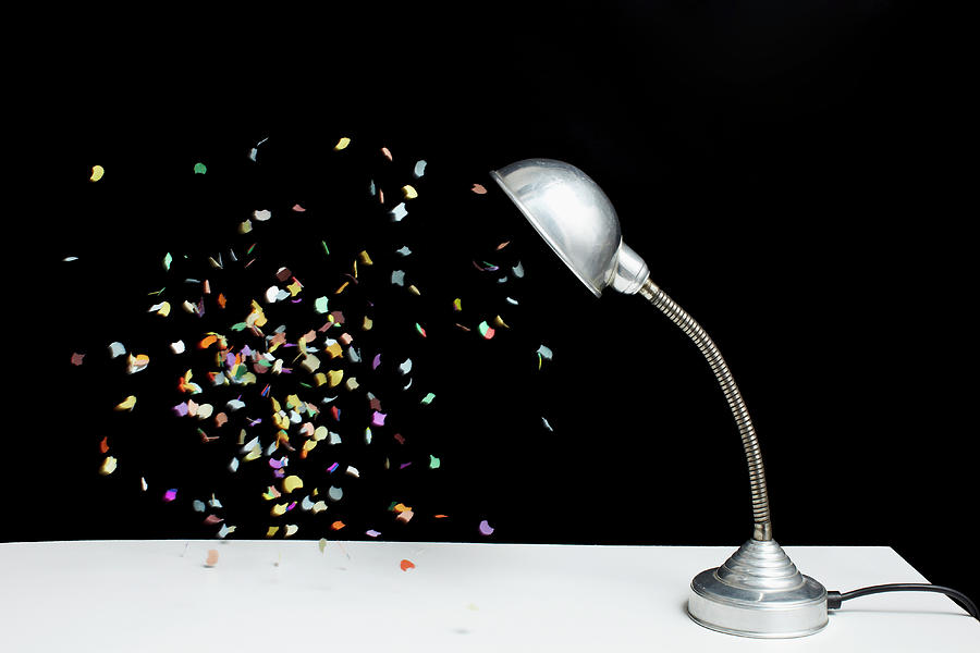 Confetti Floating Next To A Table Lamp Photograph by Benne Ochs