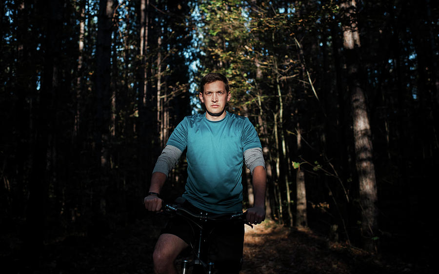 Tree Photograph - Confident Man Sitting On Mountain Bike Against Trees In Forest by Cavan Images