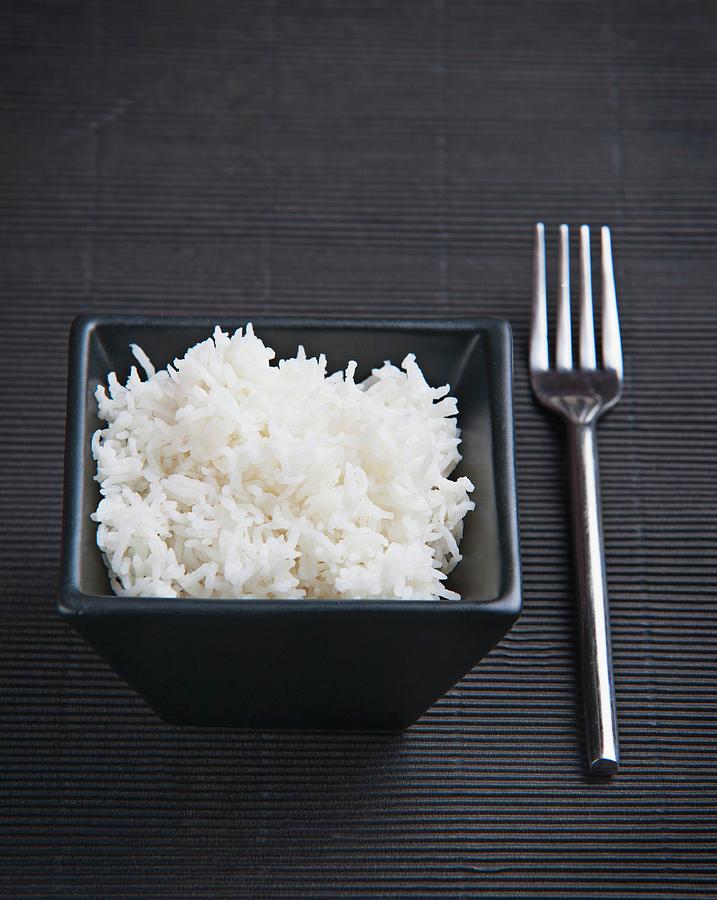 Cooked Rice In A Black Dish On A Black Surface Photograph by Richard Church