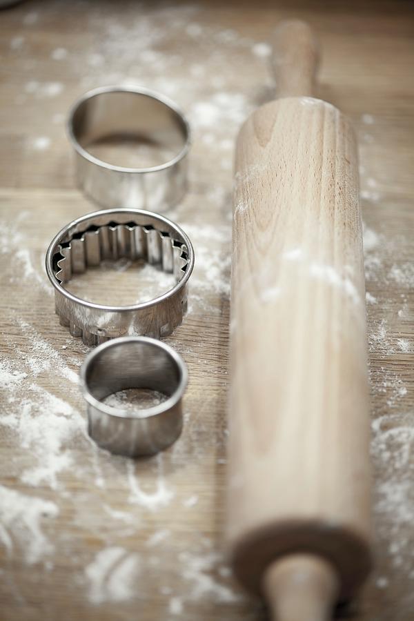 Cookie Cutters And A Rolling Pin On A Wooden Board Photograph by Eising Studio
