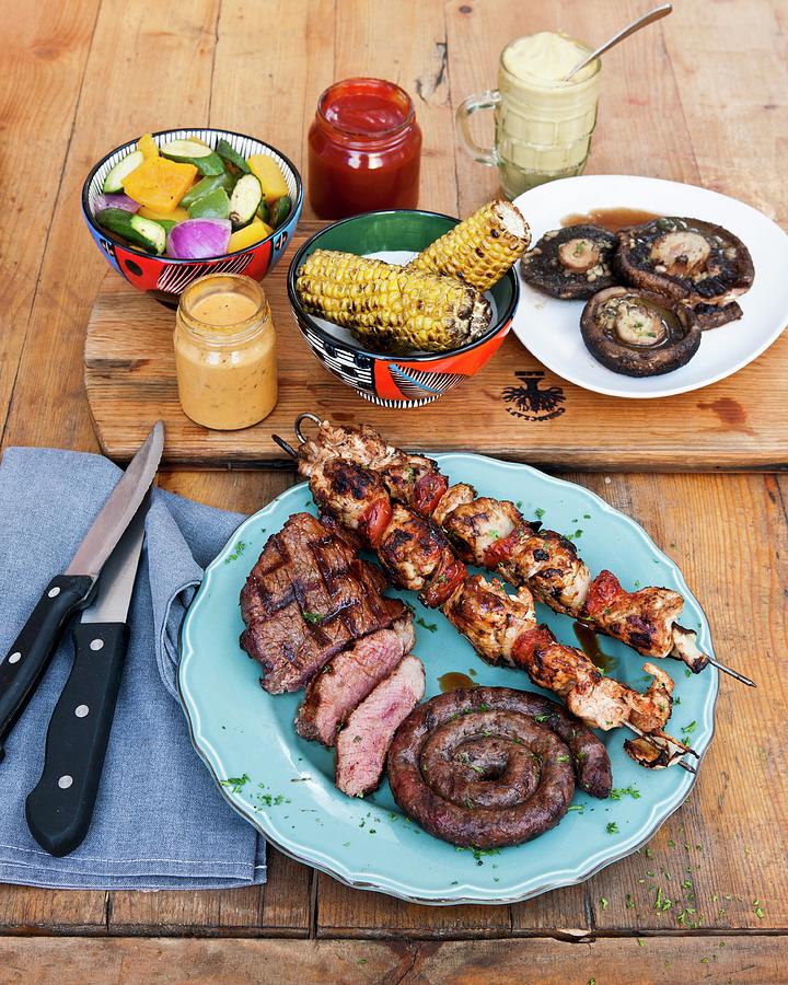 Corn Cobs And Meat, Chicken Tikka Skewers And Barbecued Steaks At The Backyard Grill Lounge, Sea Point, South Africa Photograph by Jalag / Bruce Tuck